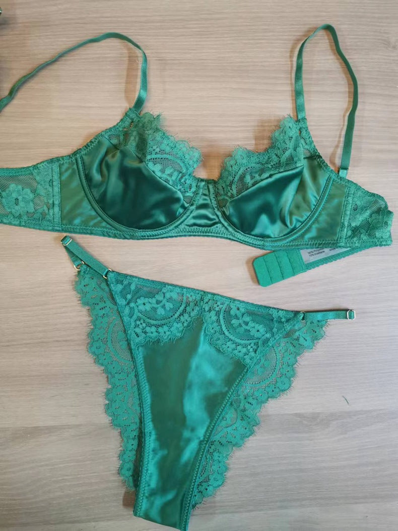 Green summer sexy lace lingerie bra and panty set with delicate floral lace details and thin straps on a wooden background