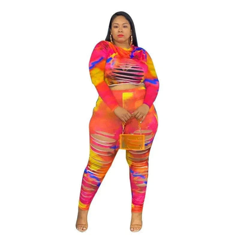 Plus size tie dye long sleeve crop top and leggings outfit with rips, vibrant colors, and matching orange purse.
