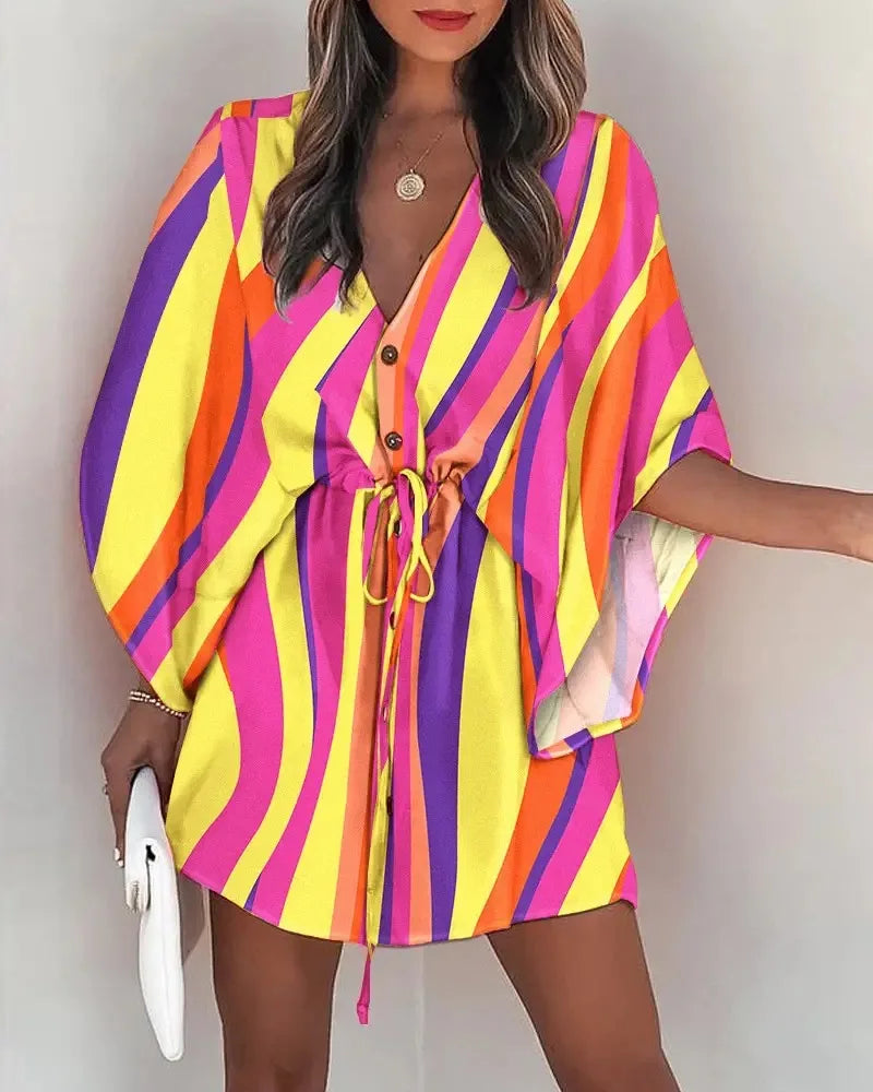 Woman wearing a colorful Fashion Print V-Neck lace-up summer dress with yellow, purple, orange, and pink stripes.