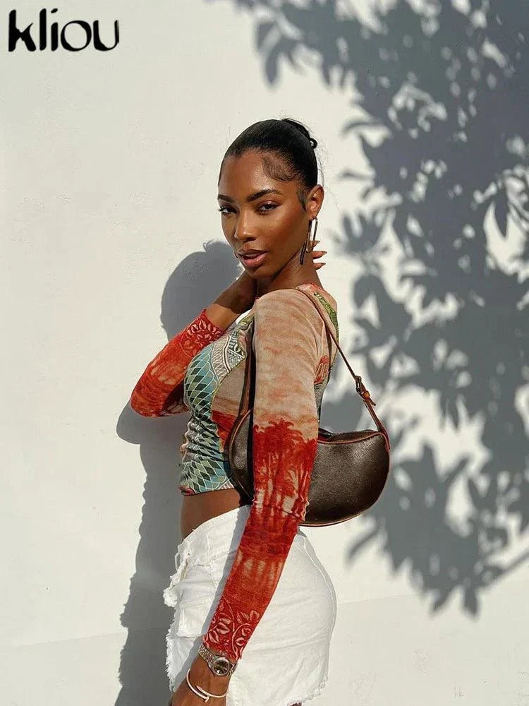 woman wearing Kliou Dollar Print long sleeve mesh tee with mixed patterns and white pants outdoors