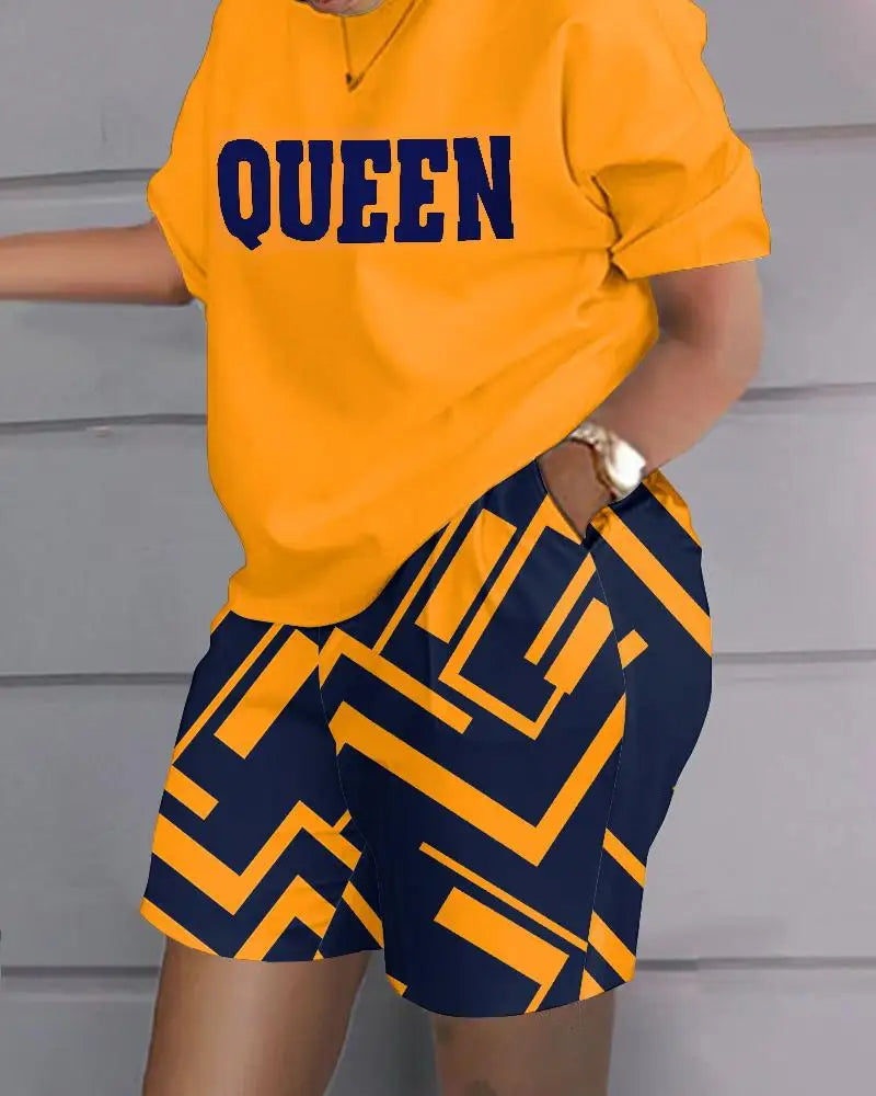 Woman wearing a summer casual 2-piece outfit with a yellow "QUEEN" printed top and navy blue geometric patterned shorts with pockets.