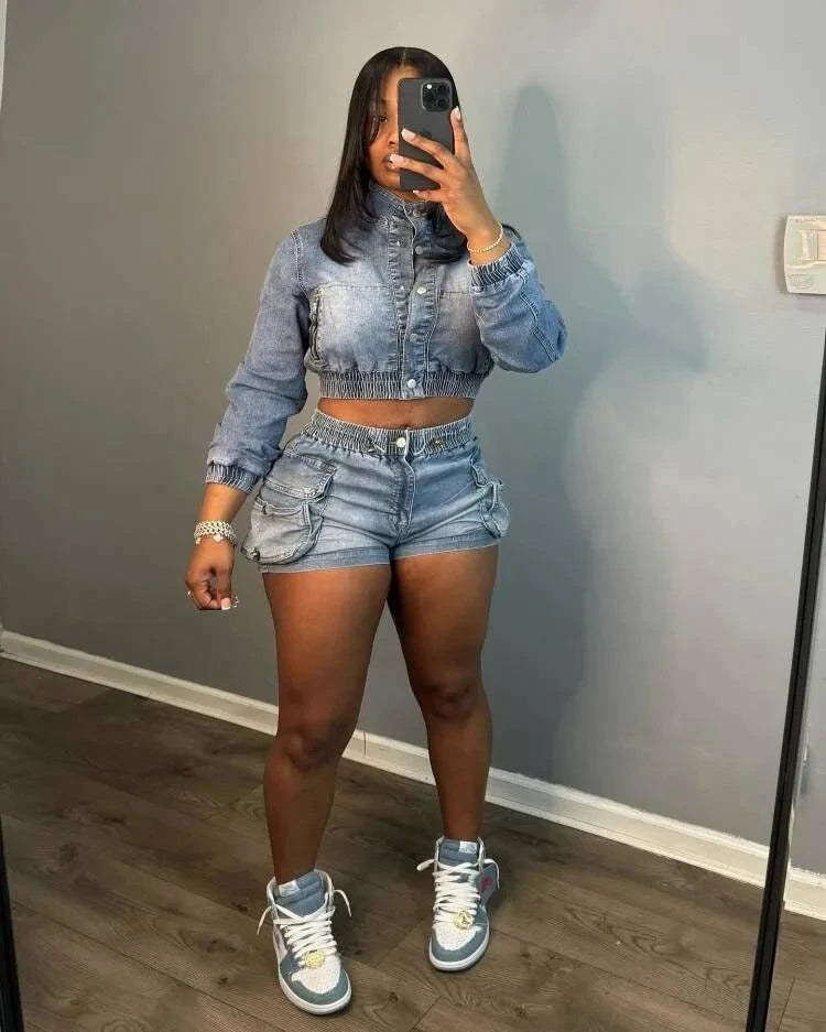 Woman wearing chic multi pocket denim shorts set with matching cropped jacket and sneakers indoors