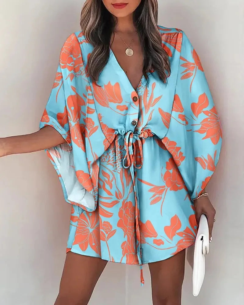Fashion print V-neck summer dress with orange floral design on blue fabric and lace-up waist detail.