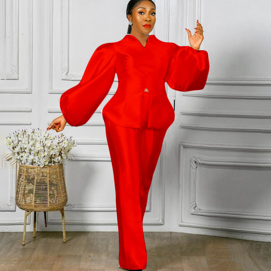 Woman wearing red women's fashion solid color puff sleeve top with wide leg pants standing indoors