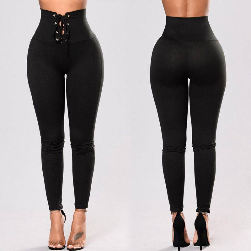 Black high-waisted rivet waist tie yoga pants with lace-up front, shown front and back on model wearing high heels