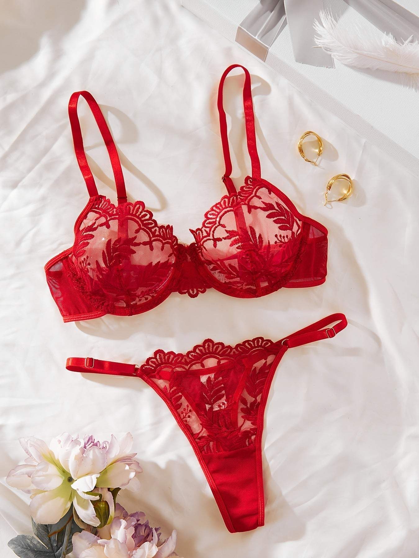 Red women's embroidered mesh lace push-up lingerie set with bra and thong on white fabric background