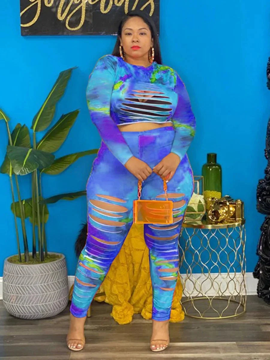 Plus size tie dye outfit with cut-out design in vibrant blue and purple tones worn by a model indoors