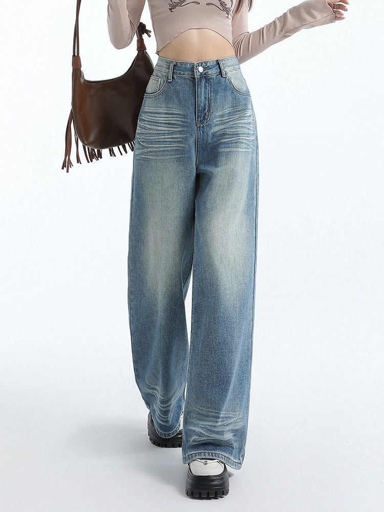 Vintage washed blue straight jeans for women with a loose fit and high waist, styled with casual footwear and a crop top.