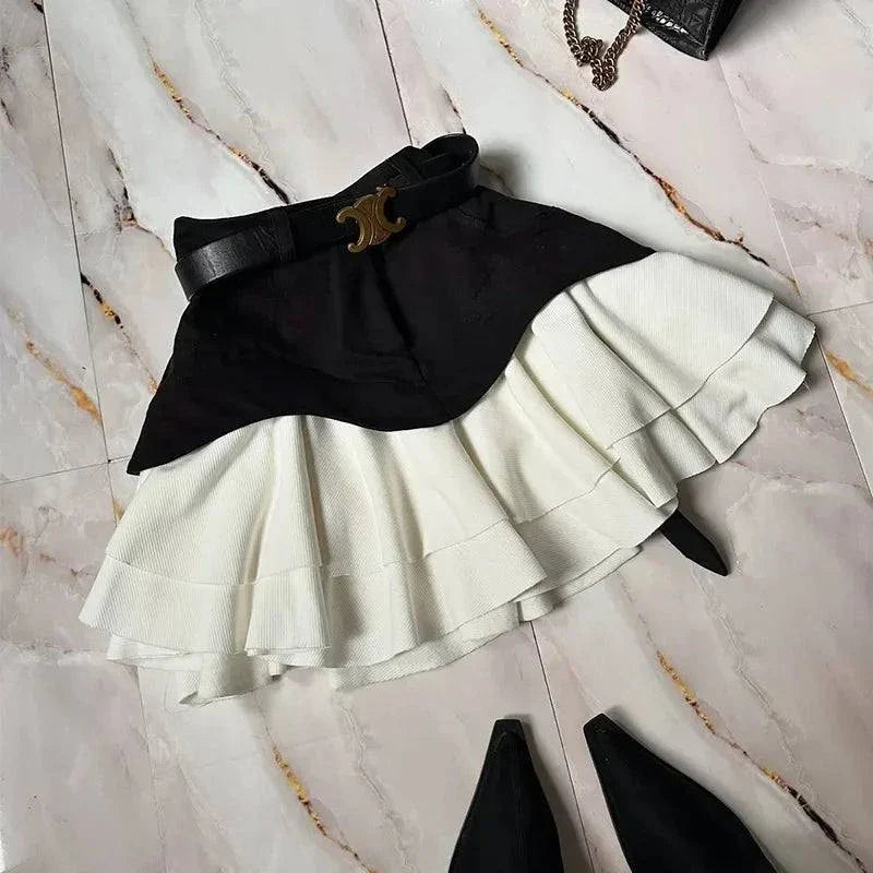 High waist ruffle edge two-tone layered skirt with black belt and pointed black shoes on marble floor