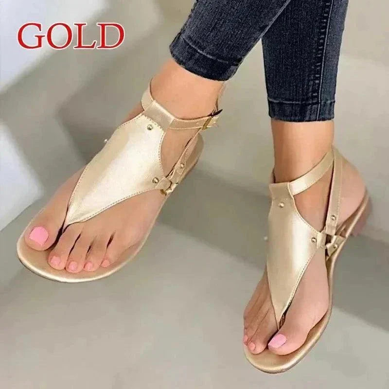 Women's gold gladiator-style fashion flip-flops with ankle straps and cushioned soles