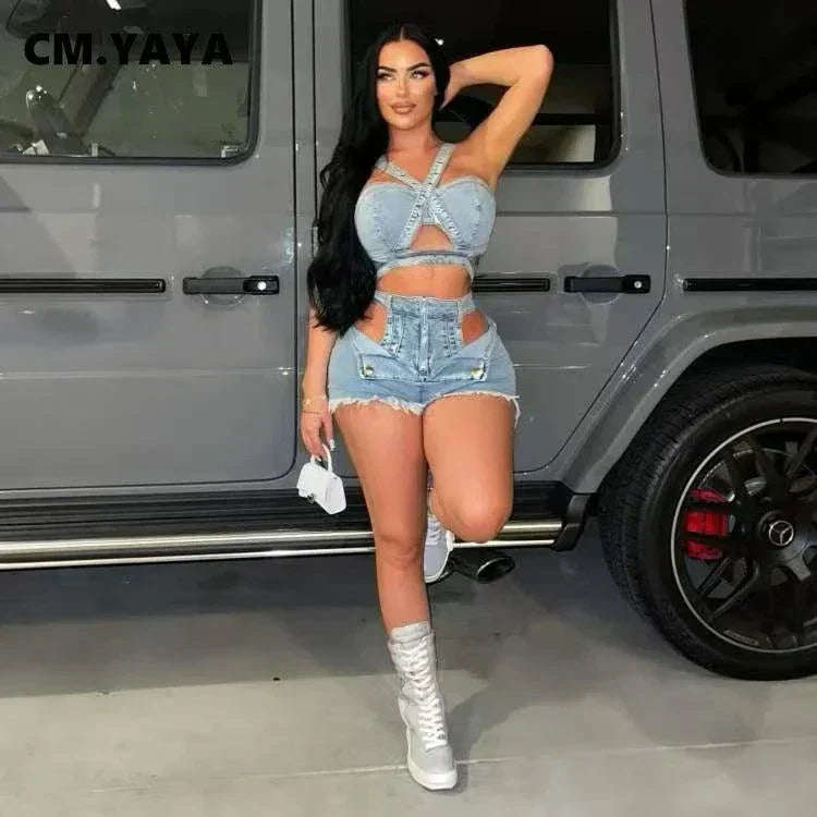 Woman wearing chic denim crop top with cutout detailing and matching high-waisted denim shorts posing by a gray luxury SUV