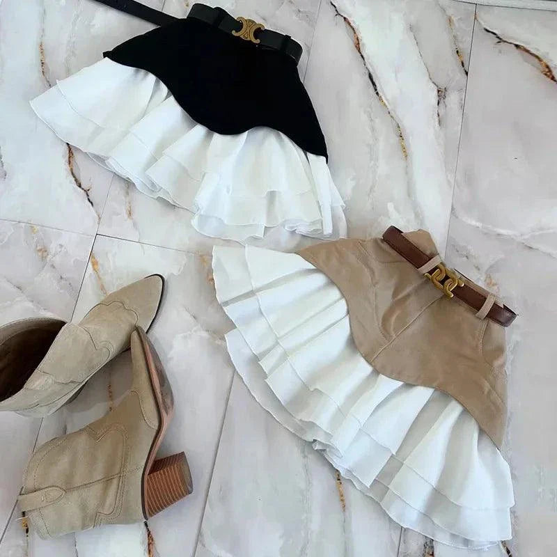 Two high waist ruffle edge denim skirts in black and beige with white ruffled hems paired with beige heeled boots on marble floor
