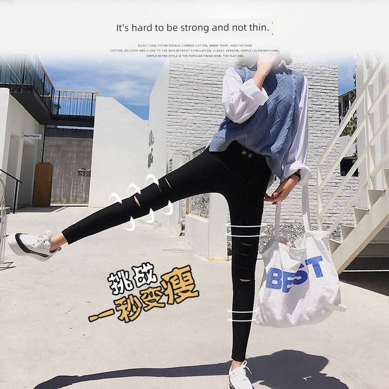 Woman wearing black ripped leggings stretching leg outdoors with casual top and white sneakers carrying a bag with "BEST" text
