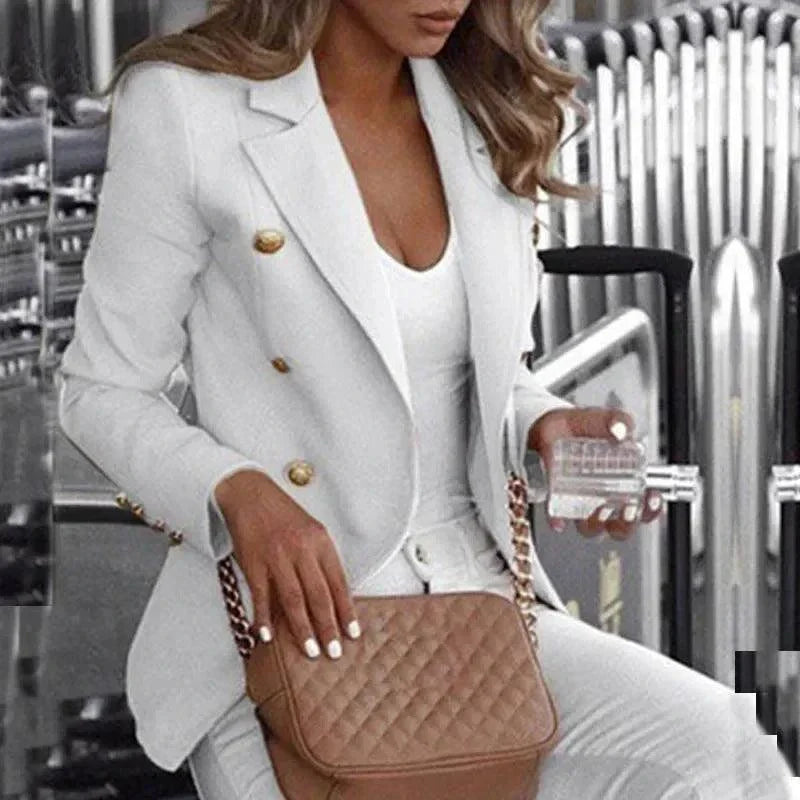 Woman wearing customizable white blazer suit with gold buttons and holding a quilted brown handbag