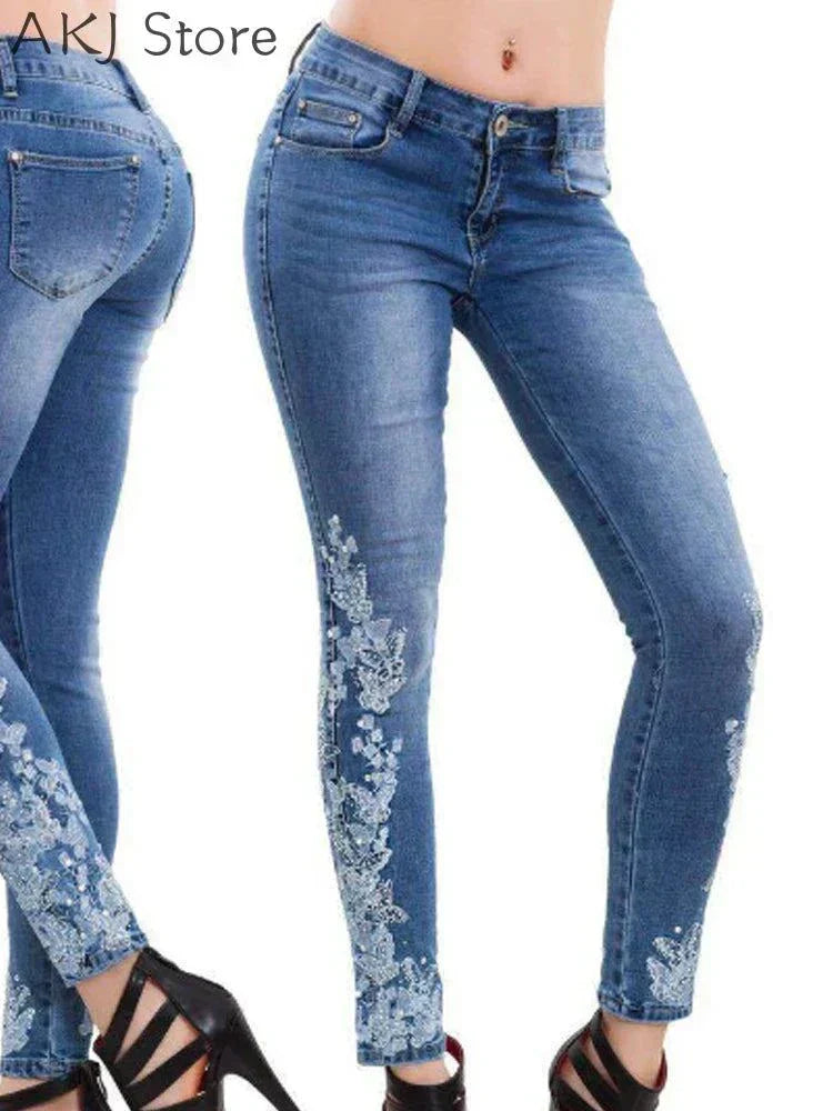 women's blue skinny jeans with white floral embroidery on legs and hips