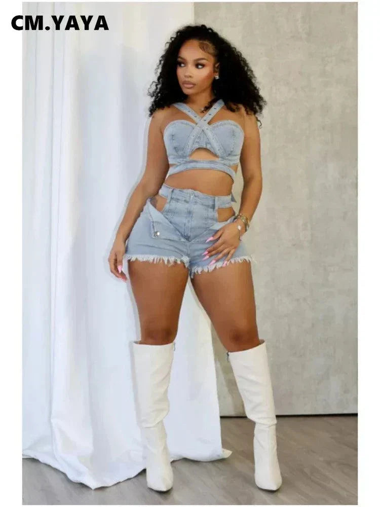 Woman wearing chic denim crop top with wrap straps and matching high-waisted denim shorts paired with white knee-high boots against a neutral background
