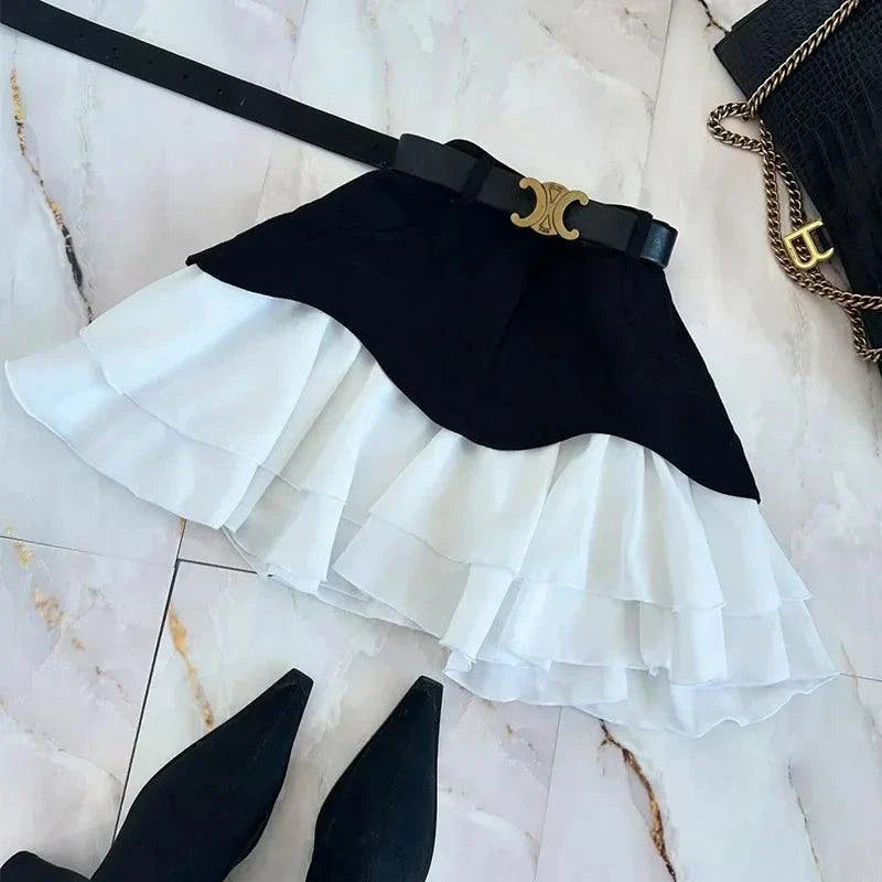 black high waist ruffle edge skirt with white layered hem and black belt on marble floor with black handbag and black pointed shoes