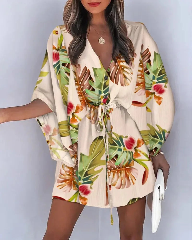 Woman wearing a floral fashion print V-neck lace-up summer dress with tropical leaves design