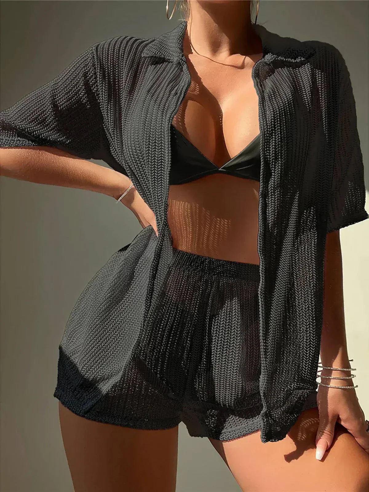 Black women's kimono cover up and matching shorts set with see-through textured fabric over black swimsuit.