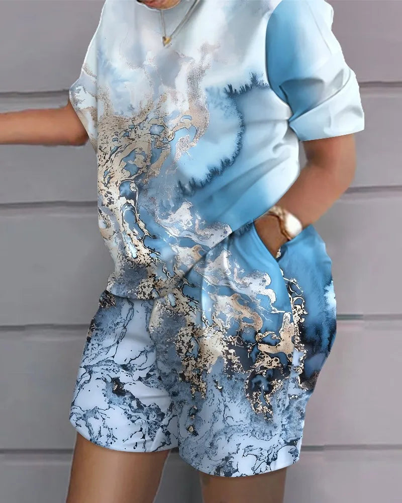 Woman wearing a stylish blue and silver marbled Summer Casual 2-Piece Outfit with short sleeves and shorts with pockets.