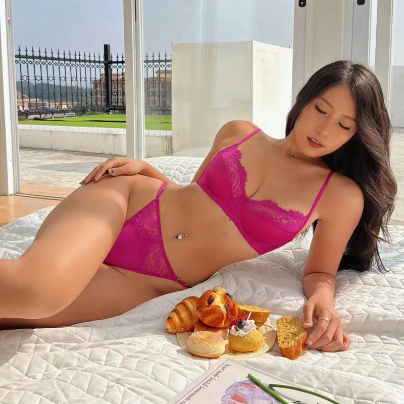 woman wearing summer sexy lace lingerie bra and matching panty in rose red color lying on bed with breakfast pastries